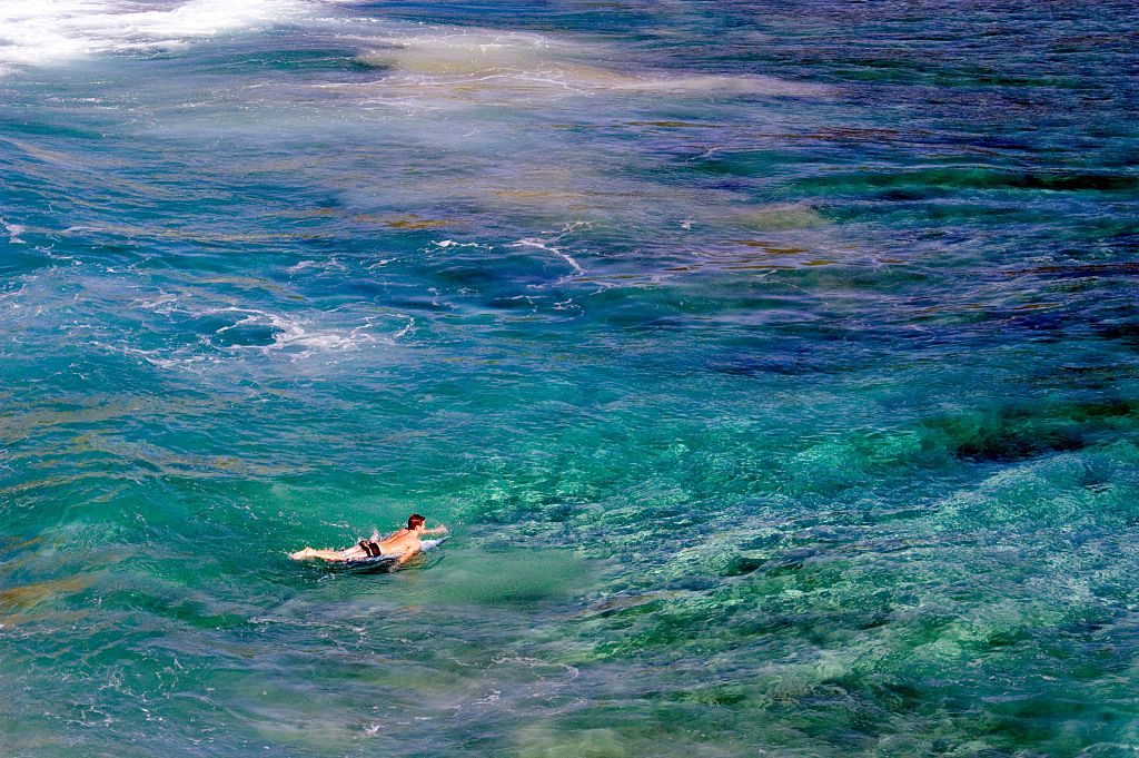 Coral_Reef_and_surfer,_Kauai,_Hawaii